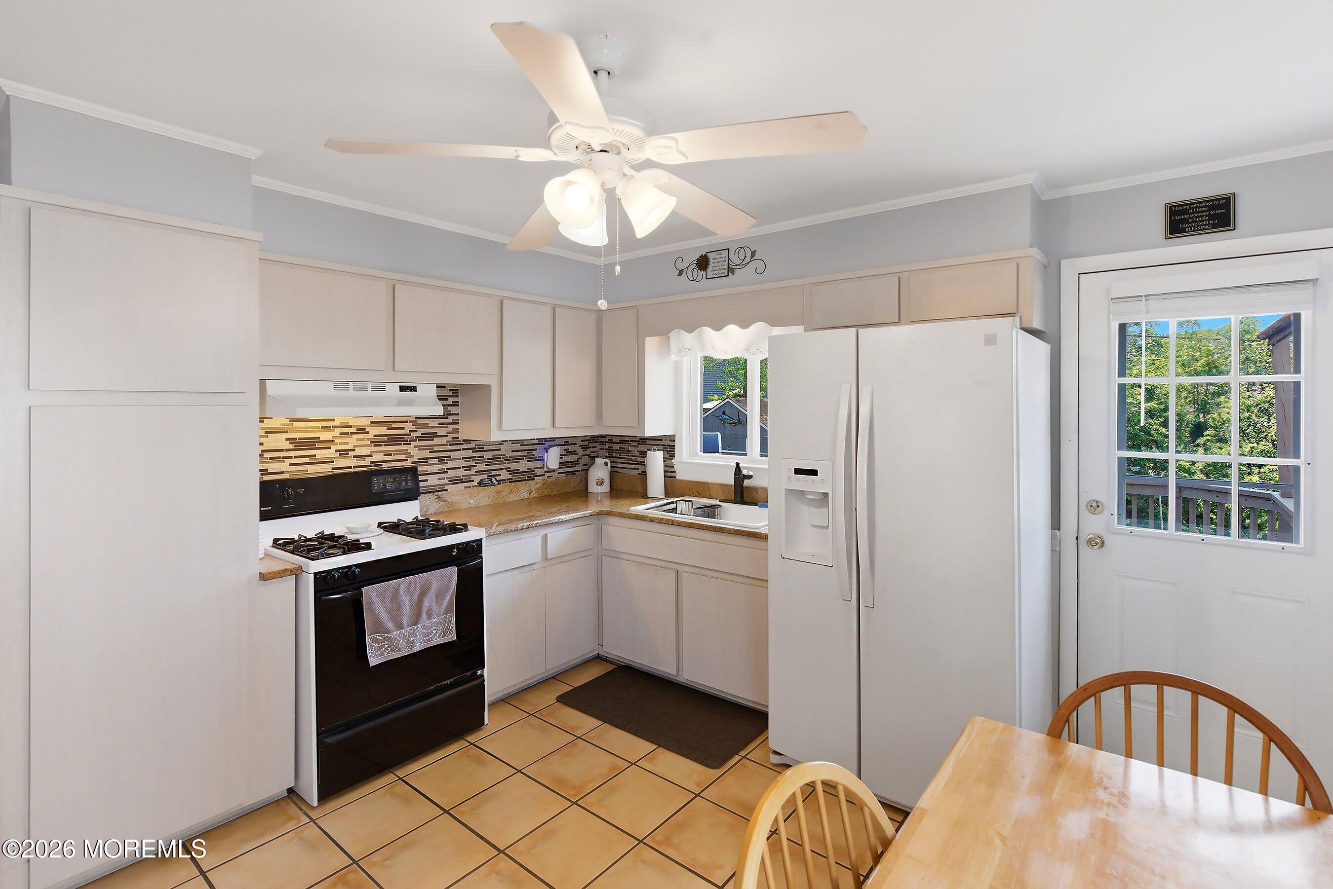 412 Moore Road Neptune Township, NJ 07753 - Photo 10 of 36 a kitchen with stainless steel appliances granite countertop a refrigerator a stove a sink and white cabinets with wooden floor