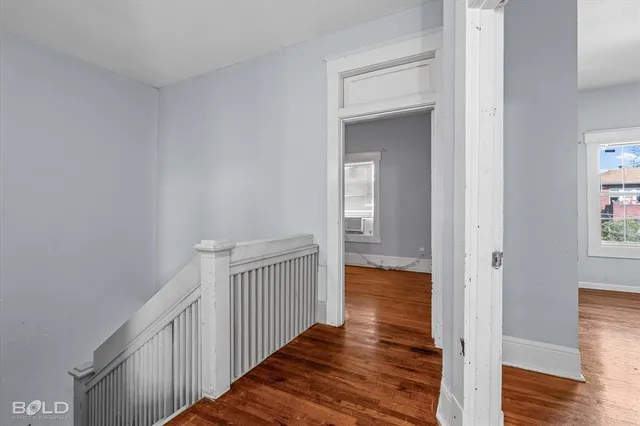 a view of a hallway with wooden floor and staircase