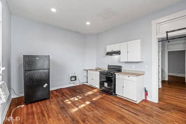 a kitchen with a refrigerator and a stove top oven