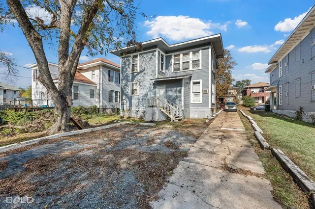 a view of large house with a yard and balcony