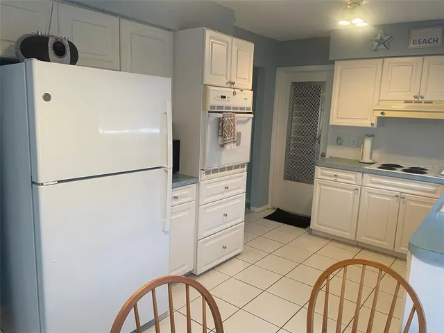 a kitchen with cabinets stainless steel appliances and a refrigerator