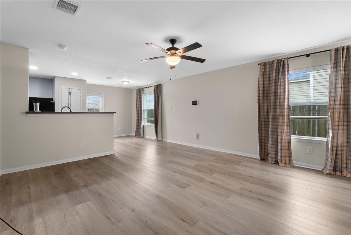 5727 Treasure Cove Road Cove, TX 77523 - Photo 7 of 20 a view of a kitchen with wooden floor and a ceiling fan