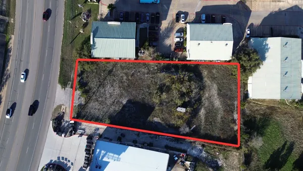 an aerial view of a house with swimming pool and large trees