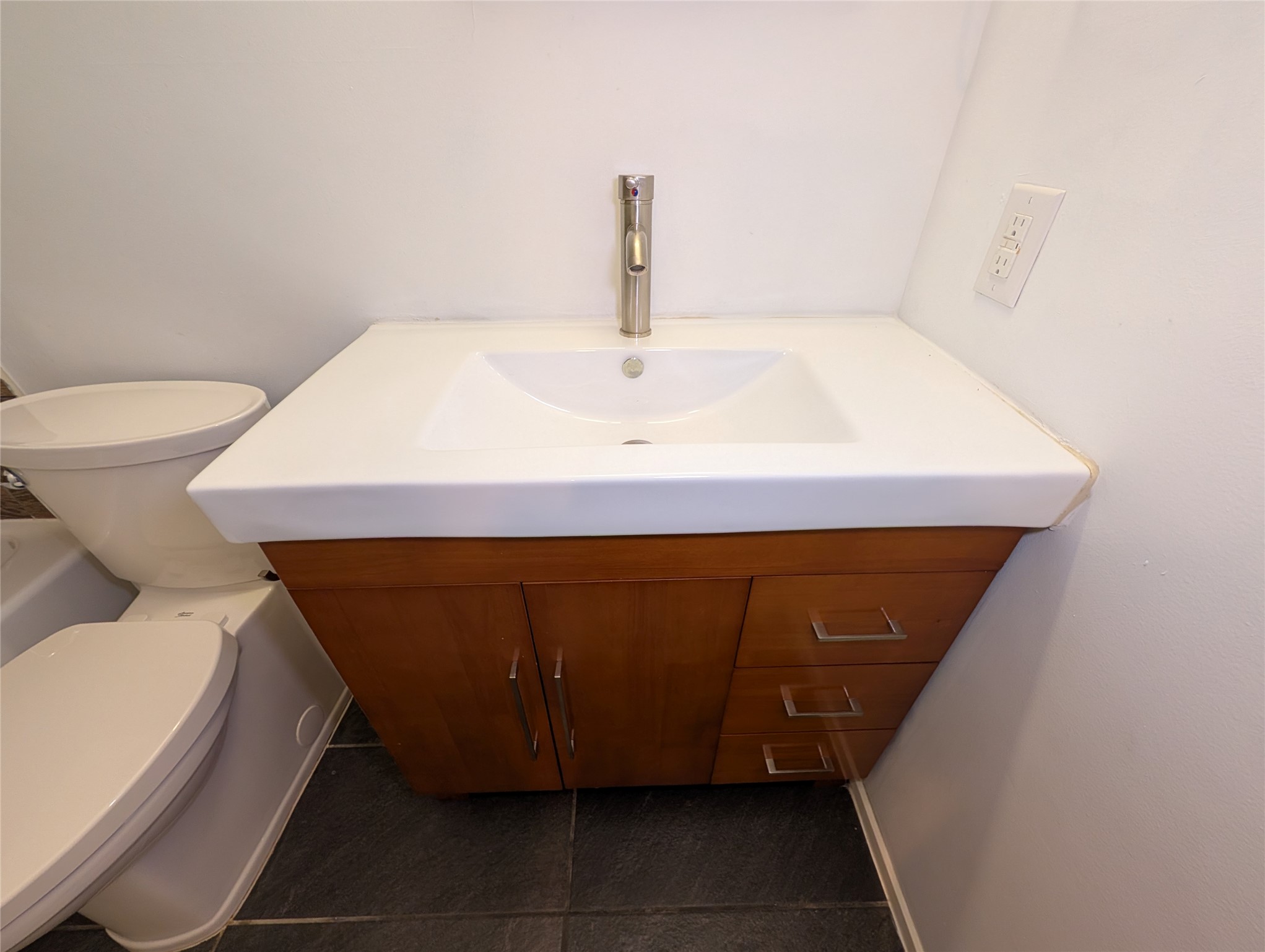 4601 Tamarack Trail Austin, TX 78727 - Photo 19 of 19 A modern vanity with sleek wood cabinetry and an integrated sink elevates this compact bathroom.