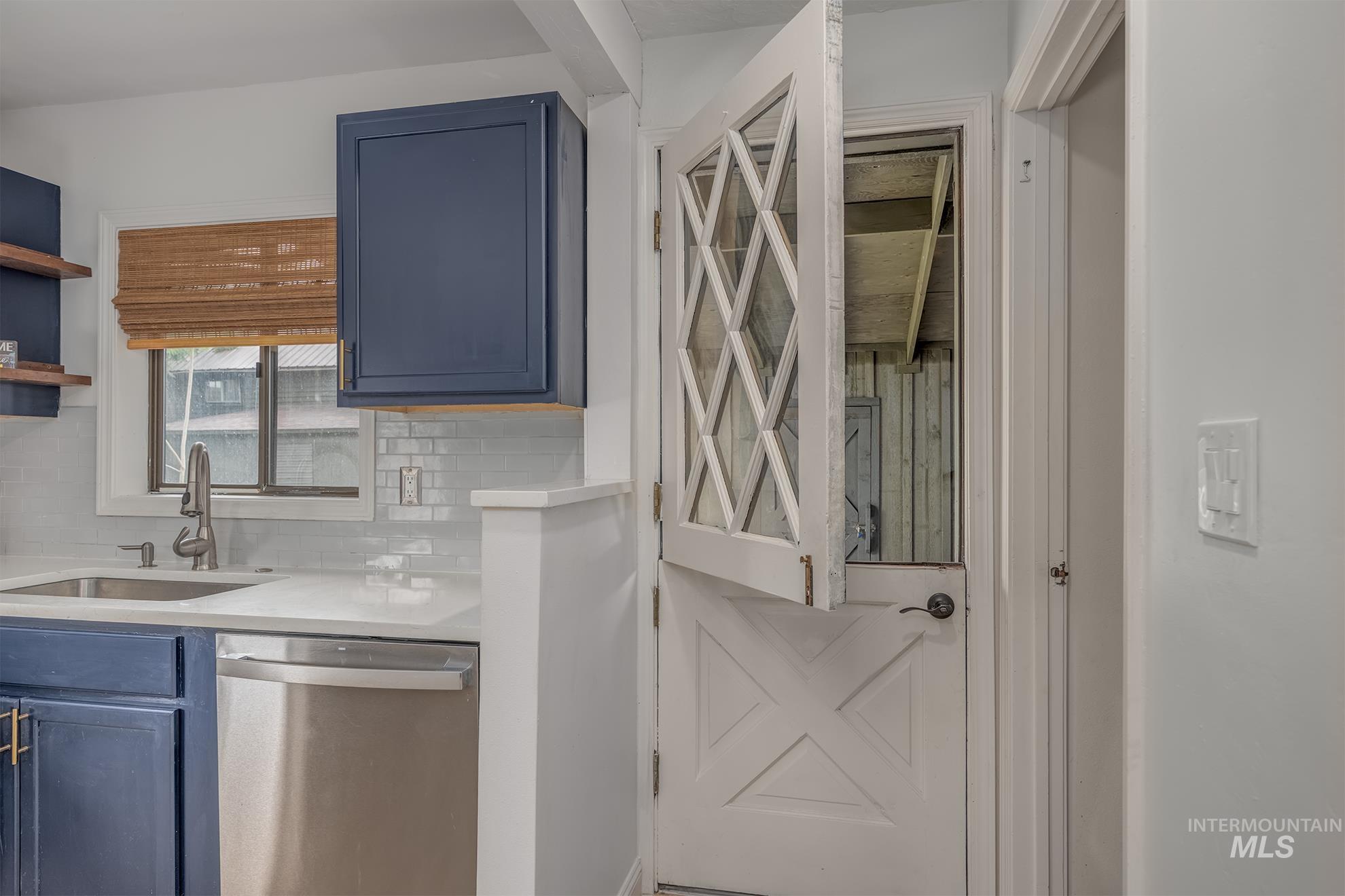 61 Southwest 4th Street Ontario, OR 97914 - Photo 12 of 42 Kitchen featuring deep blue cabinetry, stainless steel dishwasher, white subway tile backsplash, and a white countertop