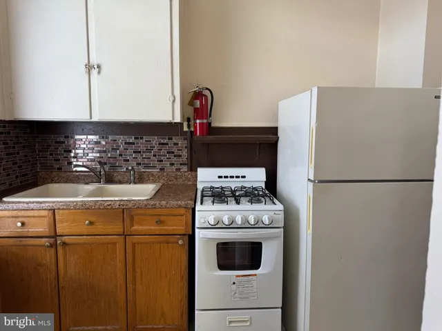 a kitchen with a refrigerator sink stove and cabinets