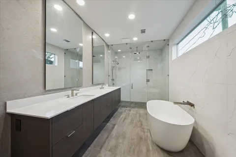 a bathroom with a white tub shower and sink