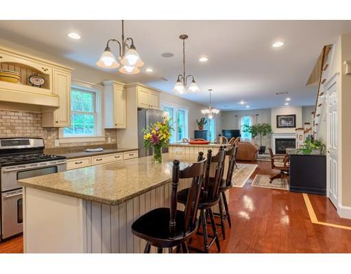 31 Boston Road Chelmsford, MA 01824 - Photo 13 of 42 a kitchen with stainless steel appliances granite countertop a table chairs and a refrigerator