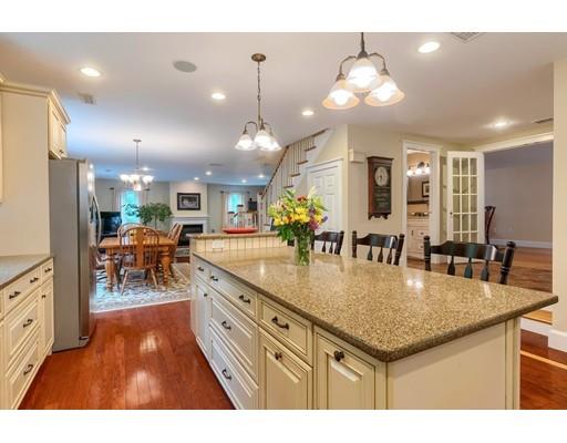31 Boston Road Chelmsford, MA 01824 - Photo 16 of 42 a kitchen with stainless steel appliances granite countertop a stove two sinks a dining table and chairs with wooden floor