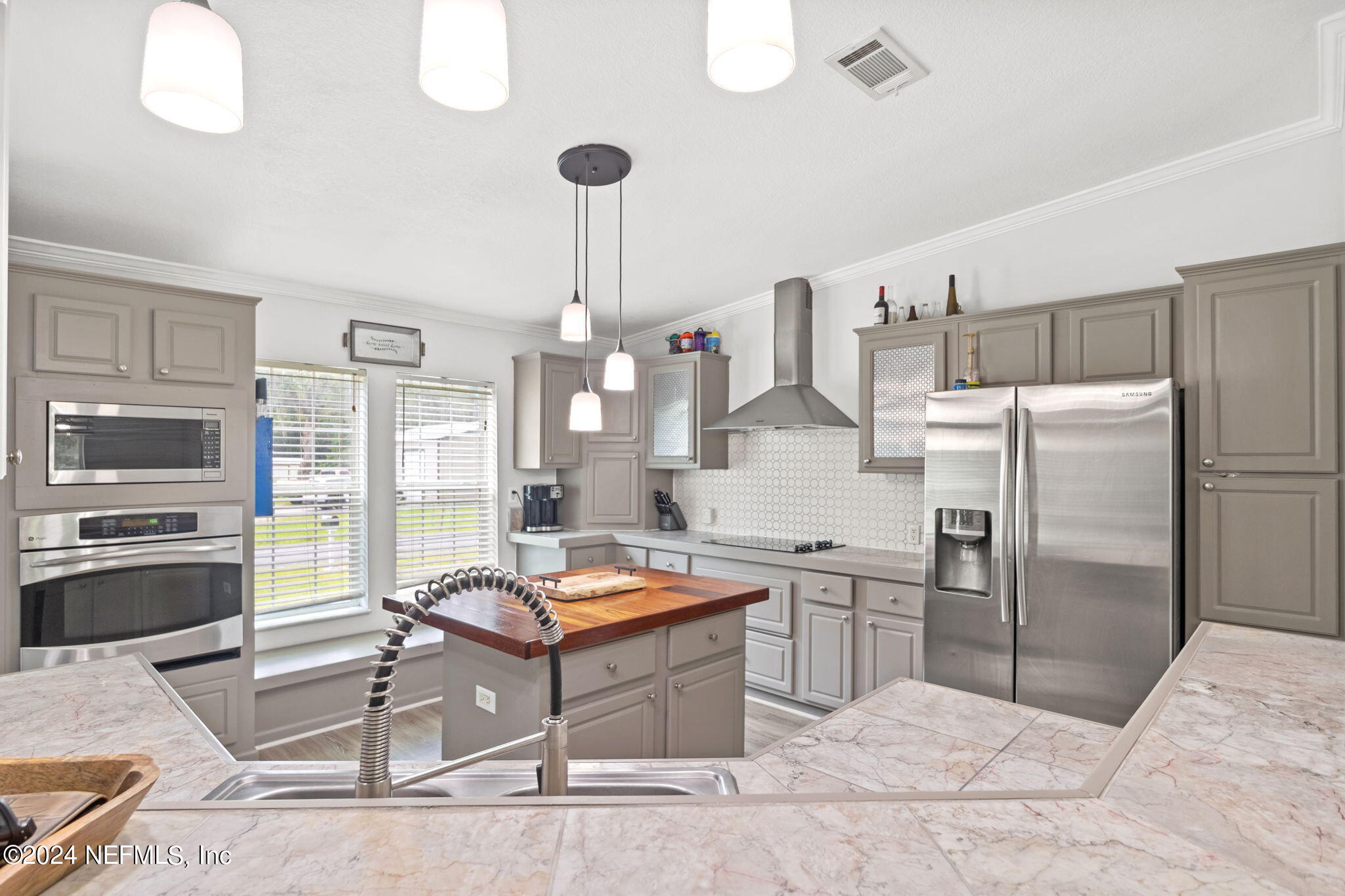 54037 Parks Road Callahan, FL 32011 - Photo 12 of 26 a kitchen with stainless steel appliances kitchen island granite countertop a refrigerator and a stove top oven