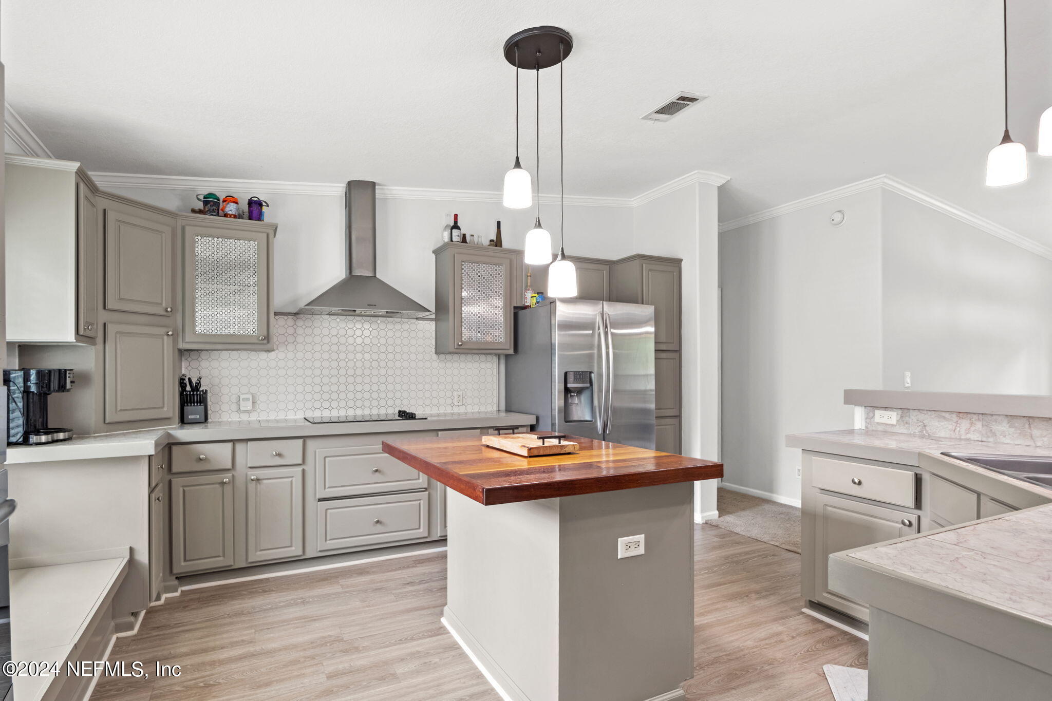 54037 Parks Road Callahan, FL 32011 - Photo 10 of 26 a kitchen with stainless steel appliances kitchen island a white stove a sink dishwasher and white cabinets with wooden floor