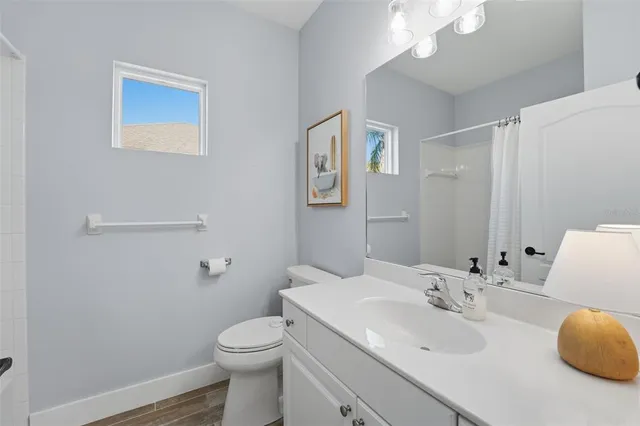 a bathroom with a double vanity sink mirror and toilet