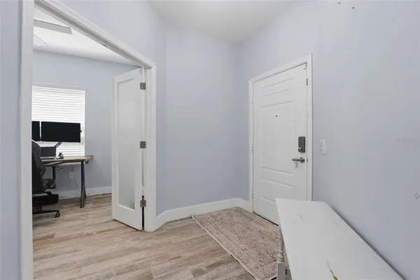 a view of a hallway with wooden floor and a living room