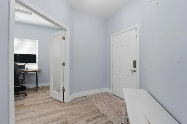 a view of a hallway with wooden floor and a living room