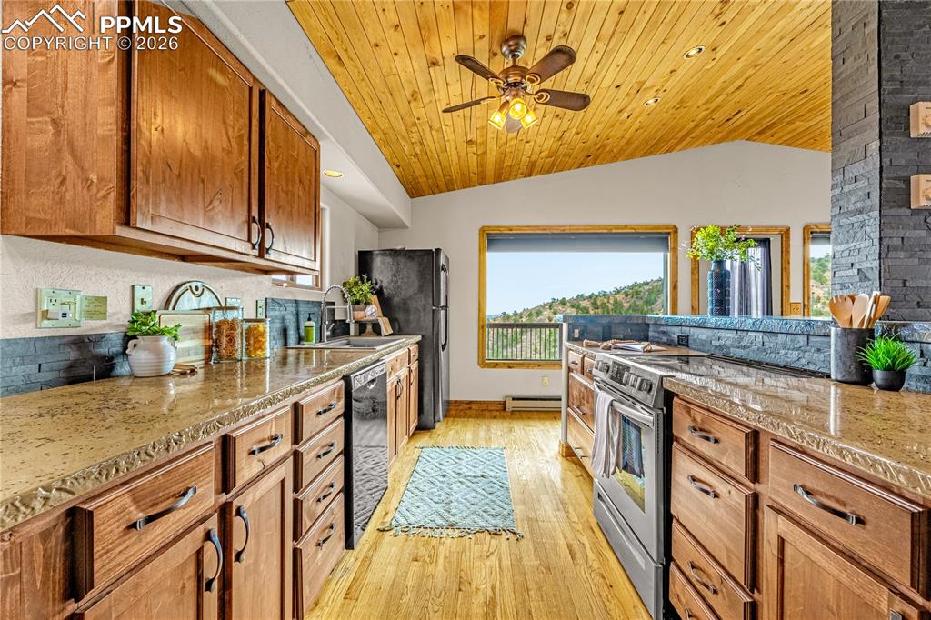 845 Crystal Park Road Manitou Springs, CO 80829 - Photo 13 of 50 a kitchen with stainless steel appliances granite countertop lots of counter top space and wooden floor