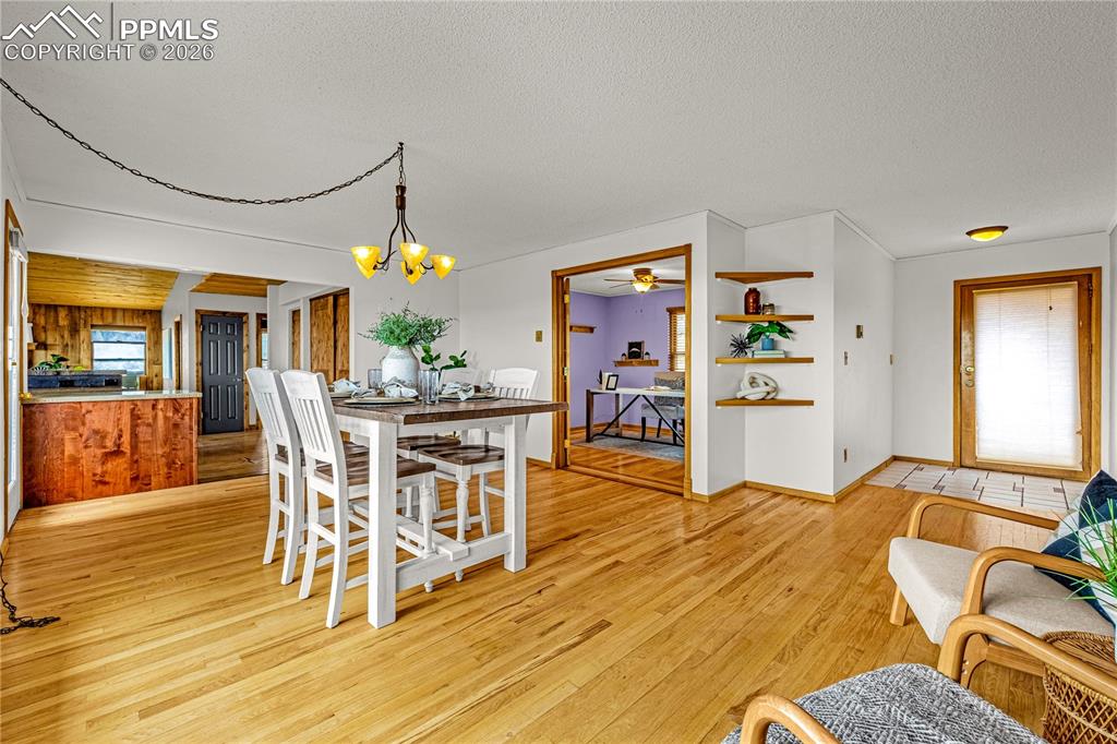845 Crystal Park Road Manitou Springs, CO 80829 - Photo 15 of 50 a dining room with wooden floor a chandelier a wooden table and chairs