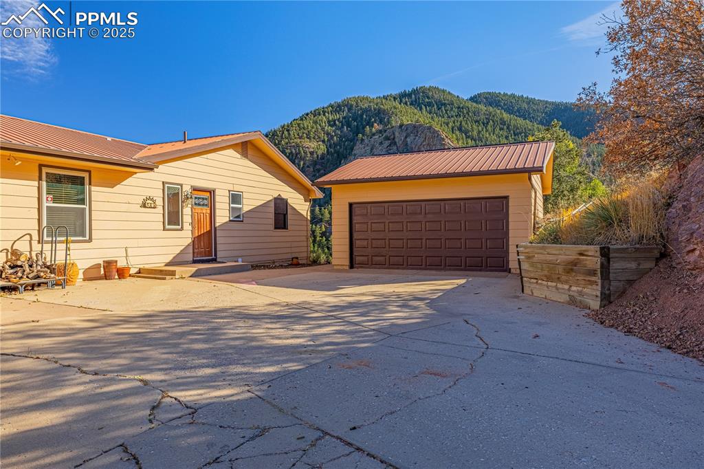 845 Crystal Park Road Manitou Springs, CO 80829 - Photo 2 of 50 a front view of a house with a yard and garage