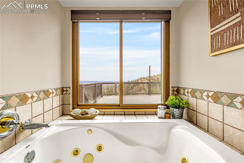 845 Crystal Park Road Manitou Springs, CO 80829 - Photo 27 of 50 a bathroom with a tub and a large window