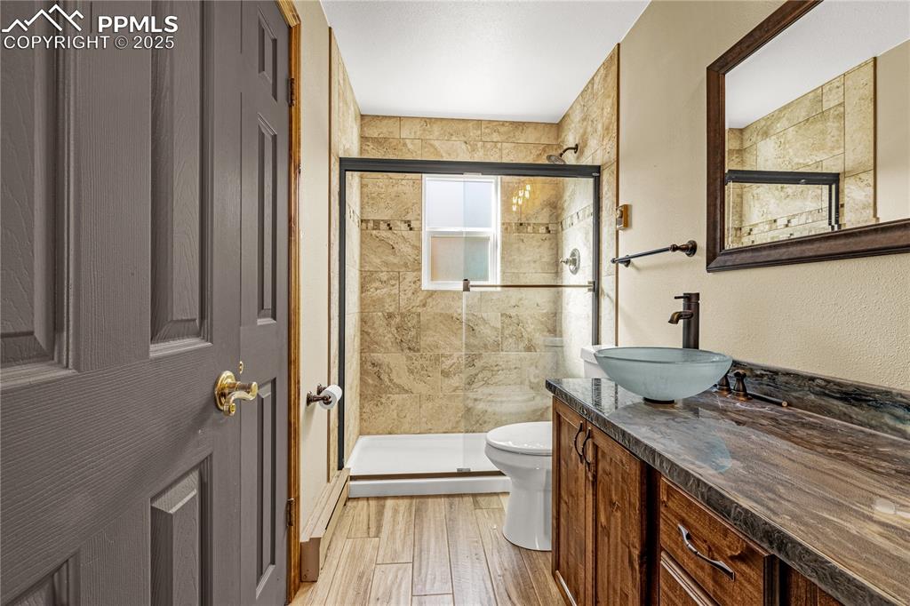 845 Crystal Park Road Manitou Springs, CO 80829 - Photo 28 of 50 a bathroom with a granite countertop sink a toilet and shower