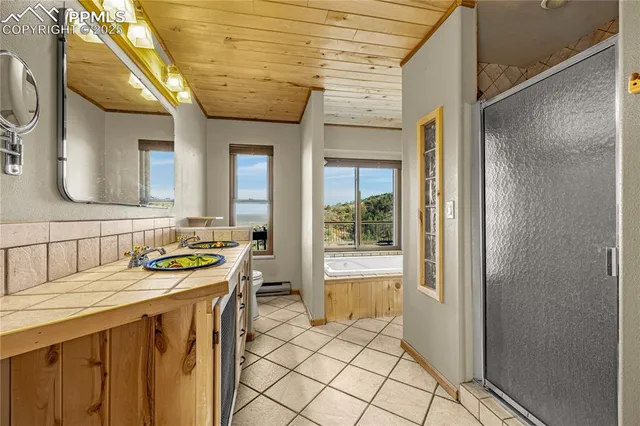 a bathroom with a granite countertop sink a mirror and a shower