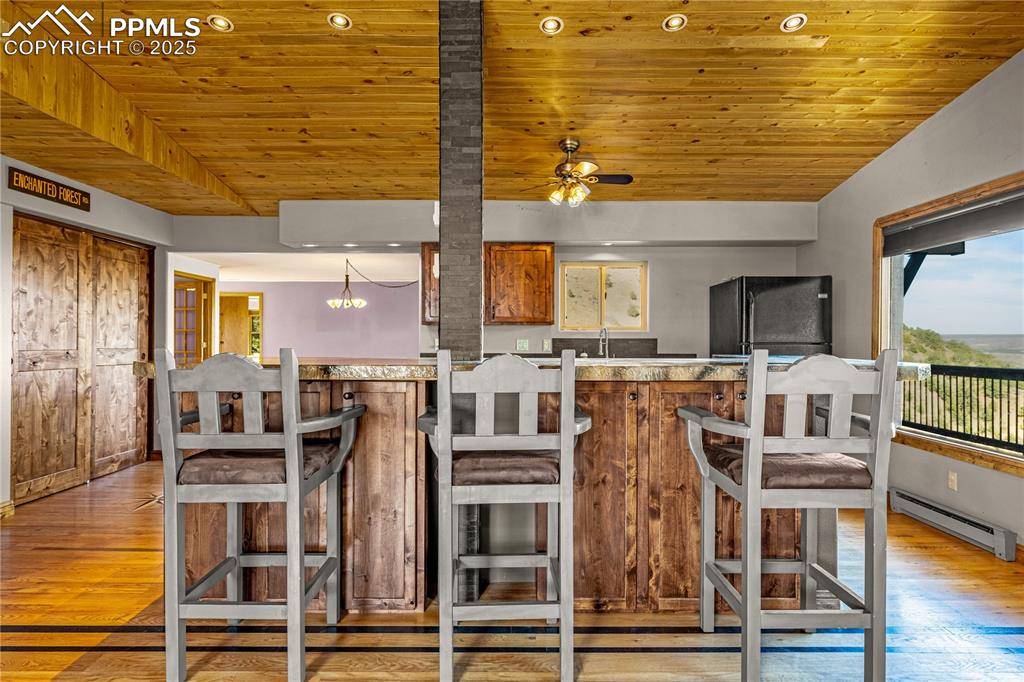 845 Crystal Park Road Manitou Springs, CO 80829 - Photo 32 of 50 a view of a dining hall with granite countertop a stove and a wooden floor