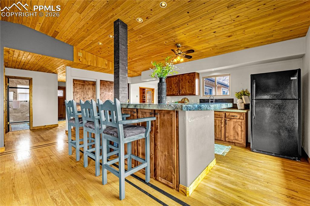 845 Crystal Park Road Manitou Springs, CO 80829 - Photo 10 of 50 a kitchen with stainless steel appliances kitchen island granite countertop dining table chairs and a large window