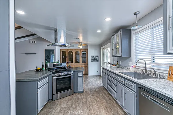 a kitchen with stainless steel appliances granite countertop a stove a sink dishwasher and a refrigerator