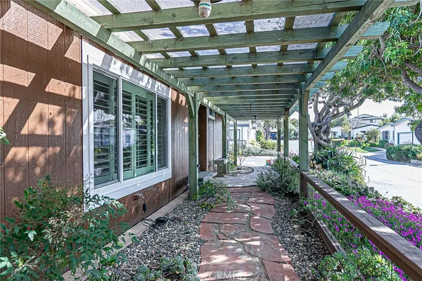 a view of house with wooden walls and potted plants
