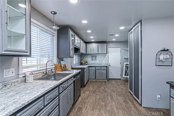 a kitchen with stainless steel appliances granite countertop sink stove refrigerator and cabinets