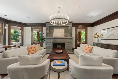 a living room with furniture a large window and a fireplace