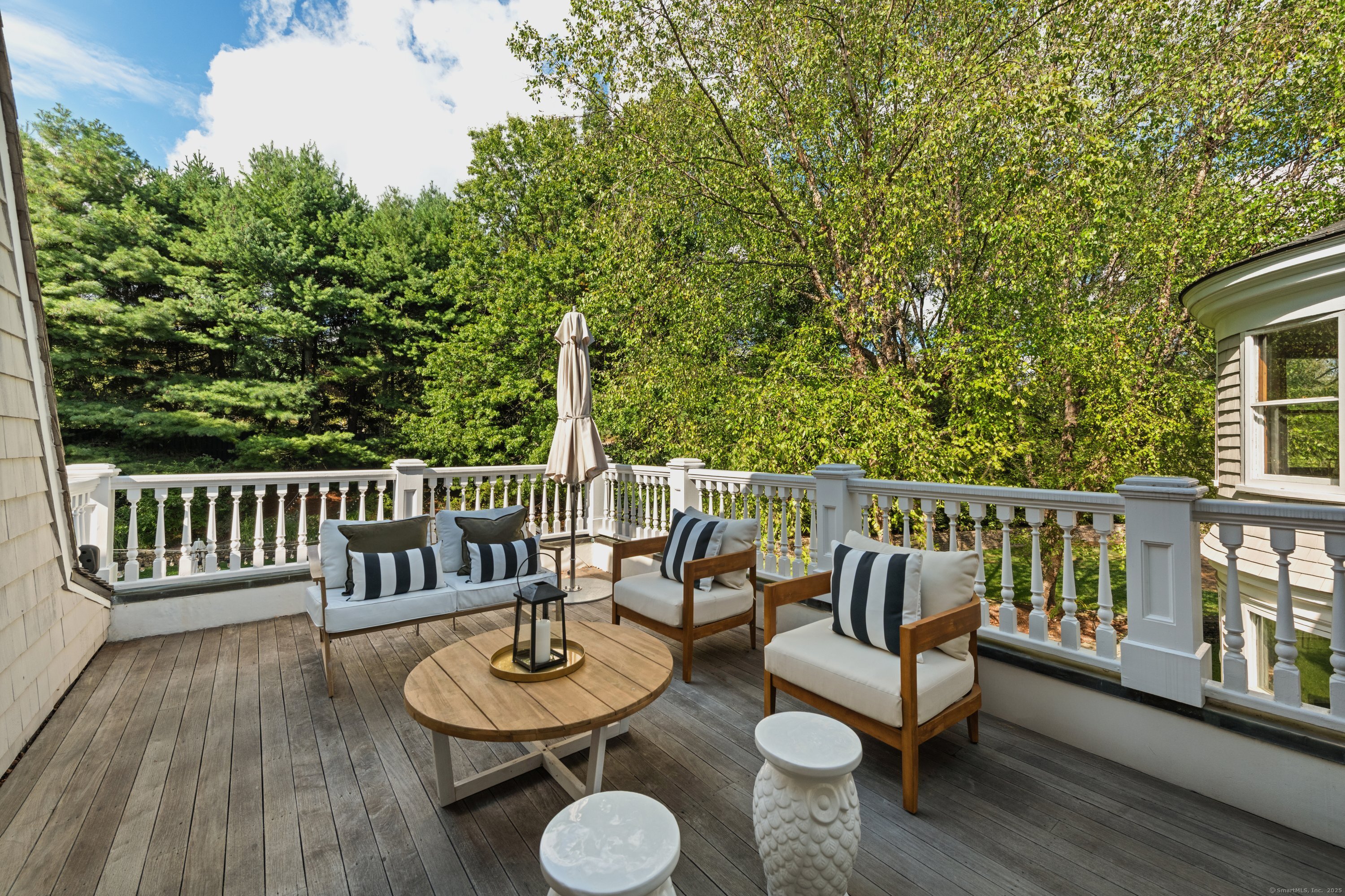 249 Greens Farms Road Westport, CT 06880 - Photo 21 of 40 a view of a deck with a table and chairs with wooden floor