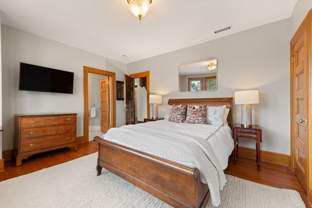 a spacious bedroom with a bed and a flat screen tv