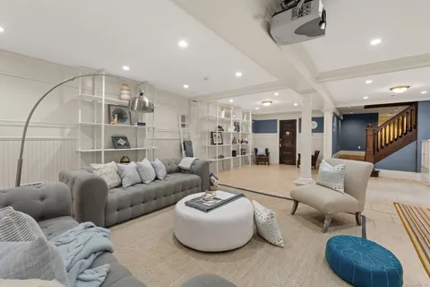 a living room with furniture kitchen view and a chandelier