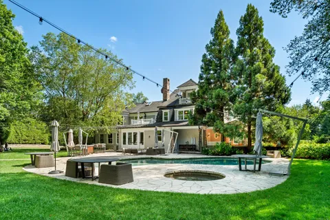 a front view of a house with garden and sitting area