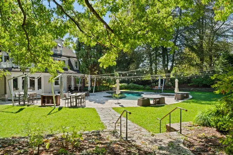 a view of backyard with swimming pool and seating space