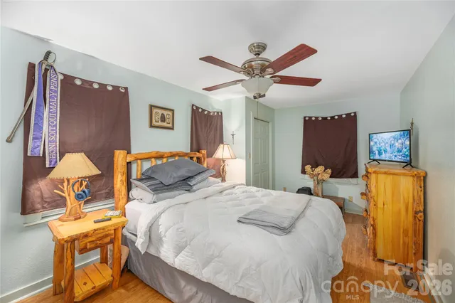 a bedroom with a bed and wooden floor