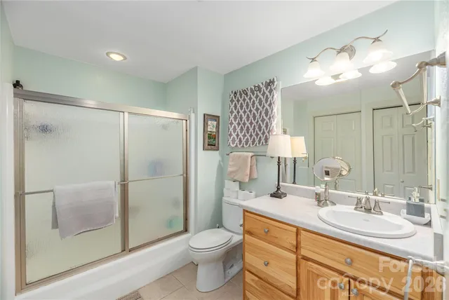 a bathroom with a toilet a sink and glass door