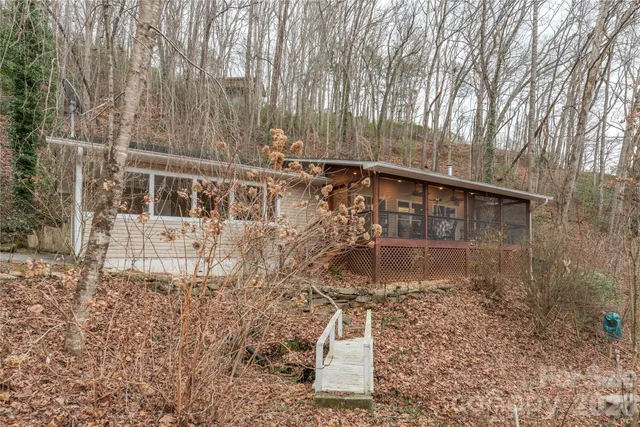 a backyard of a house with large trees and outdoor seating