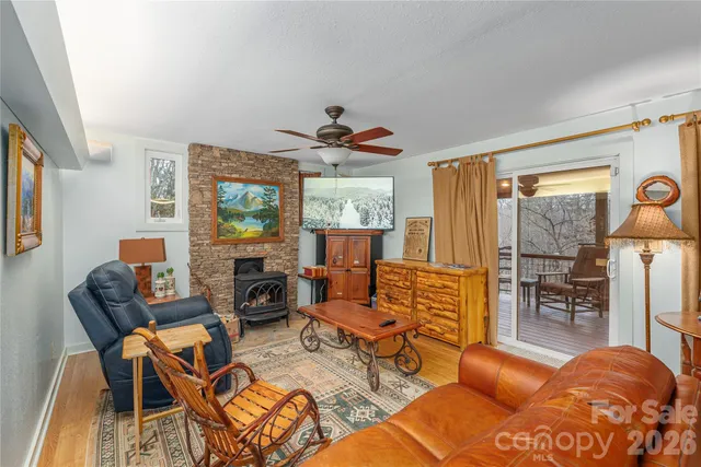 a living room with furniture a couch and two large window
