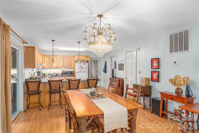 a view of a dining room with furniture a chandelier and wooden floor