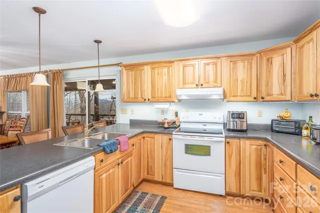 a kitchen with stainless steel appliances granite countertop a sink a stove and refrigerator