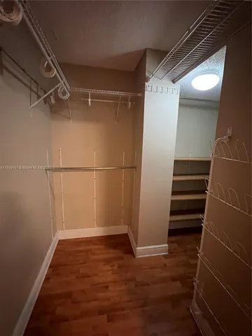 a view of a room with wooden floor and white walls