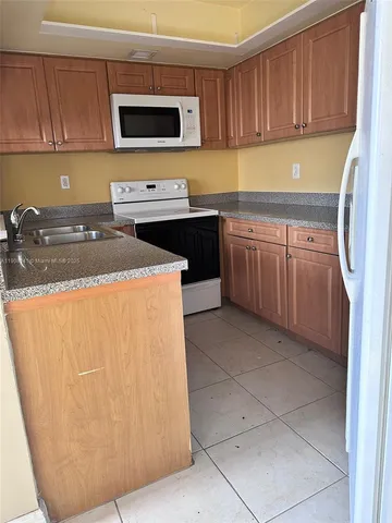 a kitchen with stainless steel appliances granite countertop a sink stove and microwave
