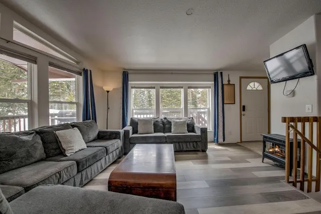 a living room with furniture large window and a flat screen tv