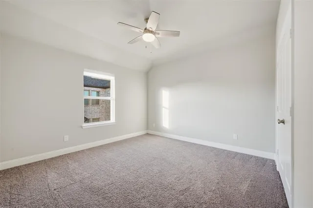 an empty room with a window and a ceiling fan