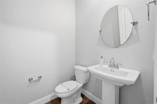 a bathroom with a sink a toilet and a mirror
