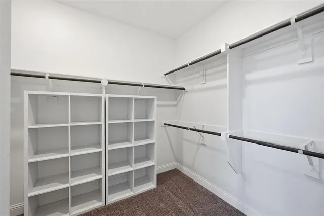 a view of walk in closet with empty racks
