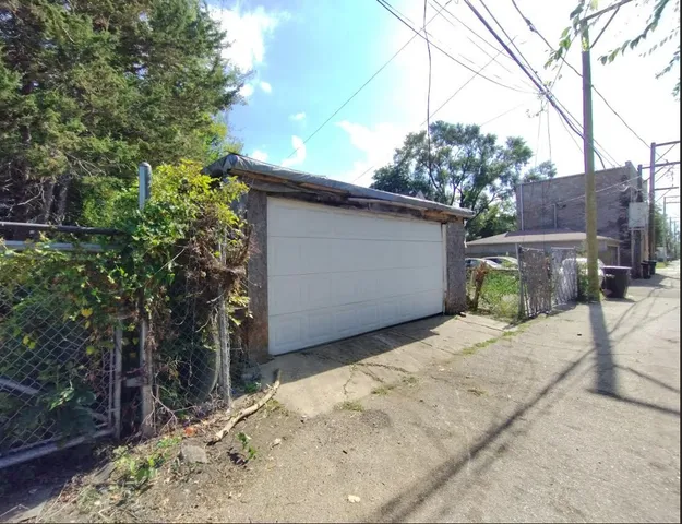 a backyard of a house with large trees and wooden fence