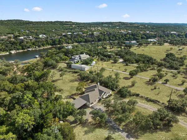 an aerial view of residential house with outdoor space and trees all around
