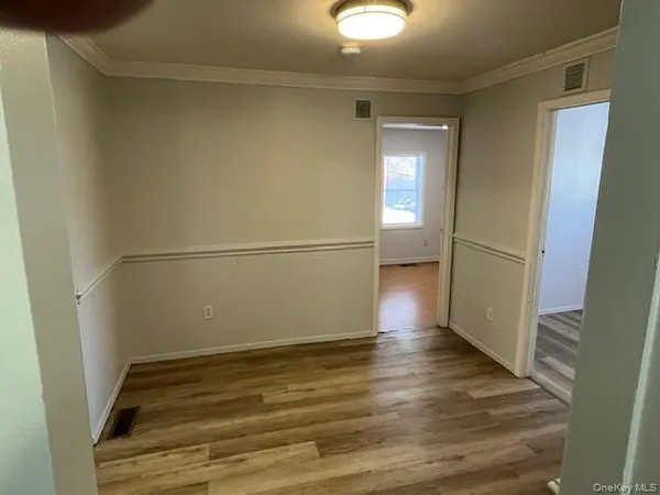 a view of a big room with wooden floor and windows